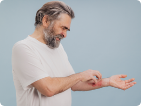 homem coçando o próprio braço